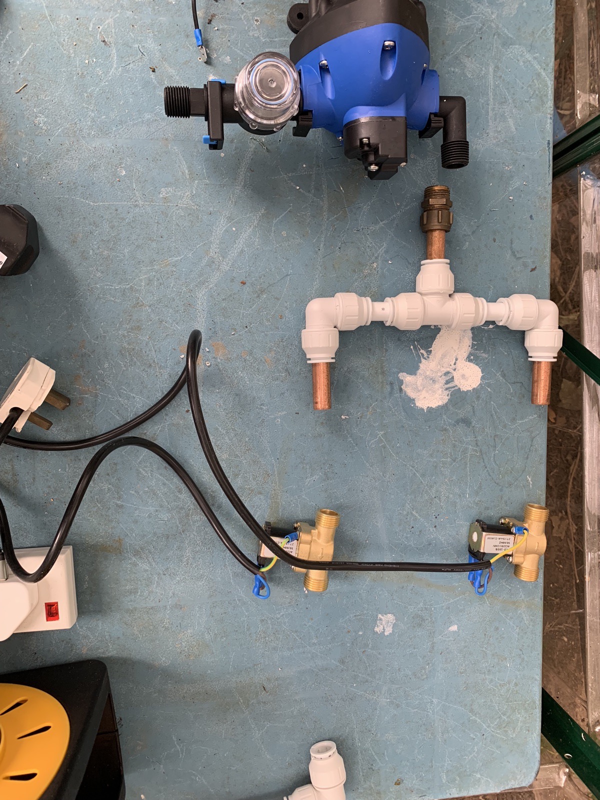 Irrigation parts laid out on a bench — pump, pushfit fittings and two brass solenoid valves